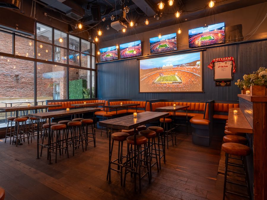 The bar and TV wall inside Printers Alley